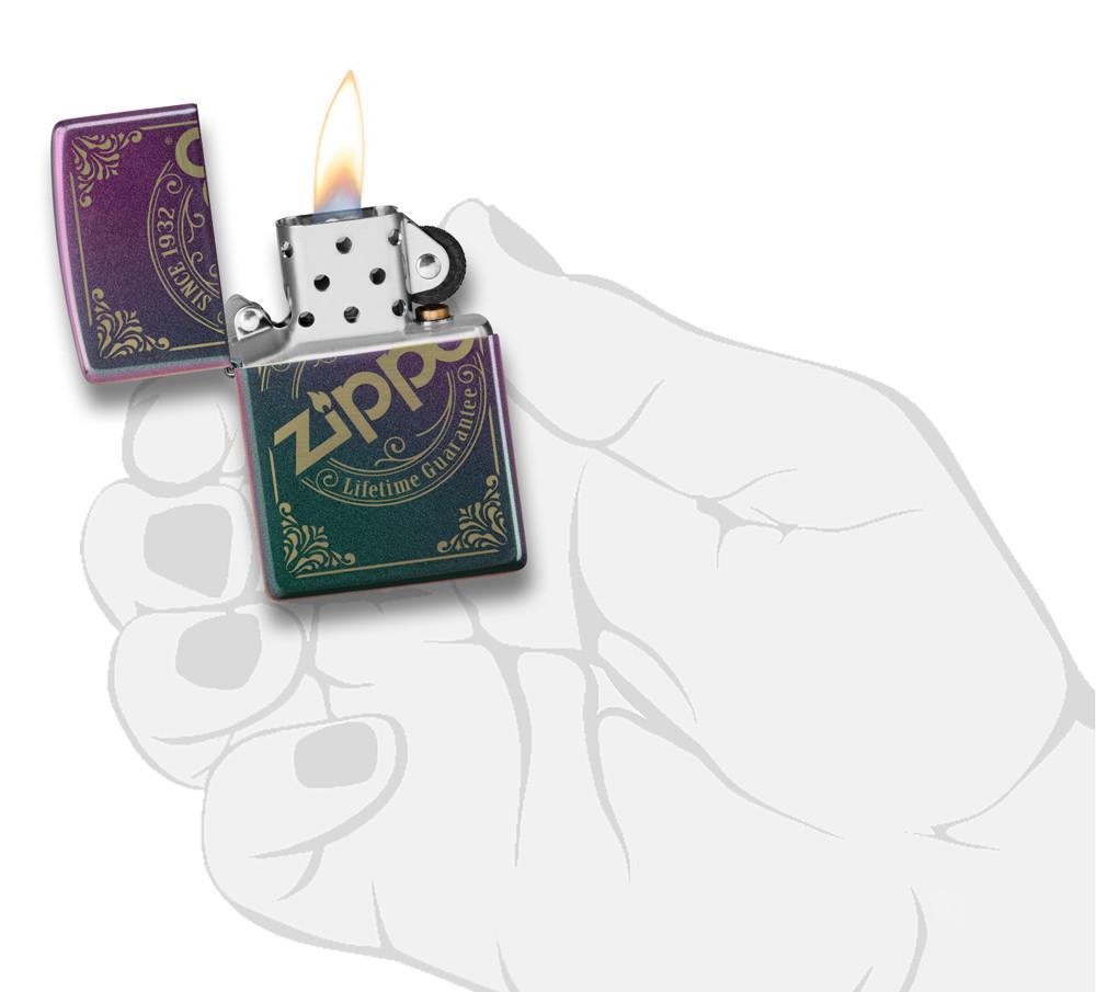 Frontansicht Zippo Feuerzeug Iridescent Matte mit Zippo Stempel Logo als Laser Gravur geöffnet mit Flamme in stilisierter Hand